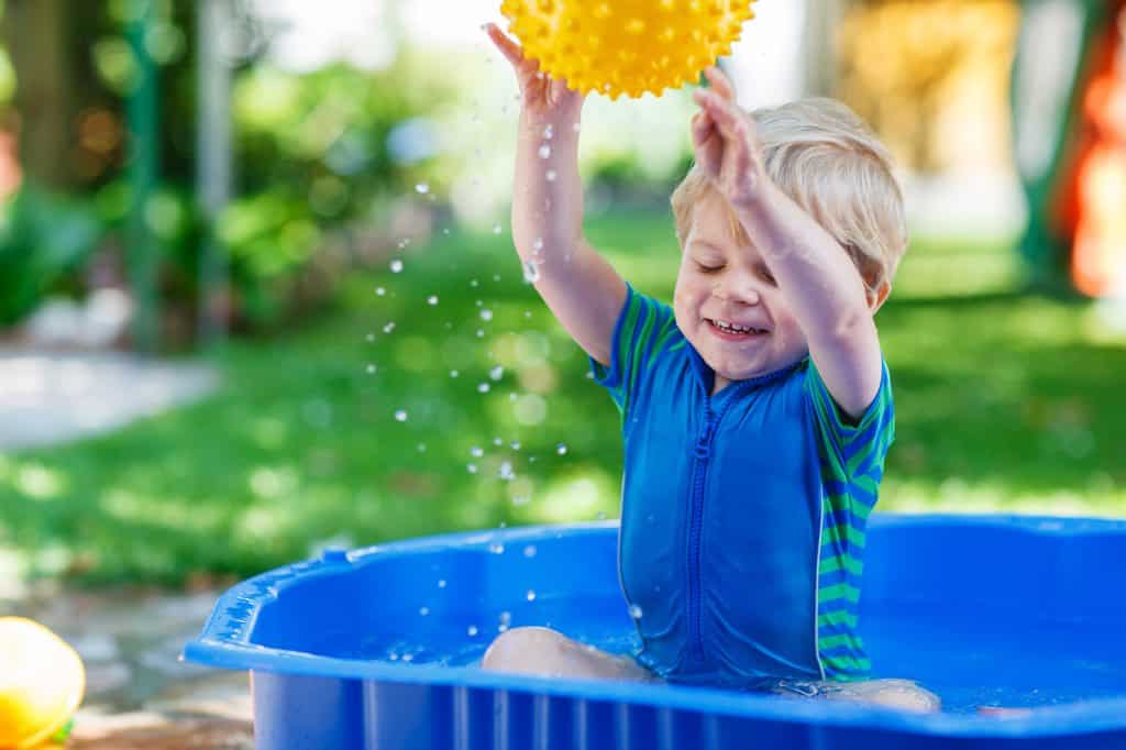 Little Toddler Boy Having Fun With Splashing Water In Summer Gar